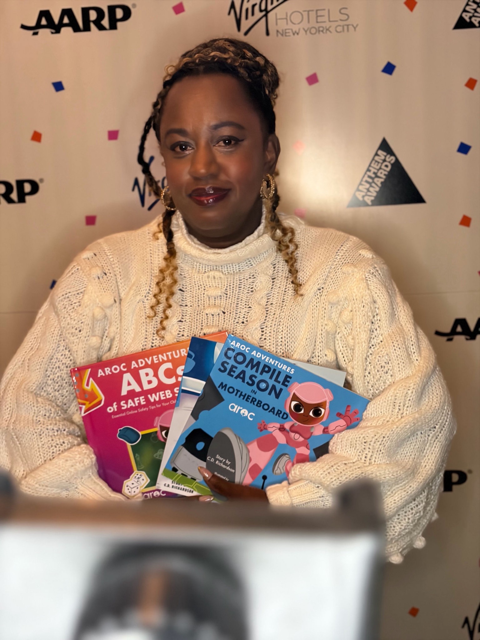 Cora Richardson holding AROC Adventures books at an Anthem Awards event